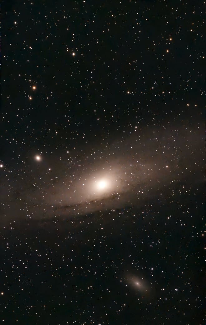 The Andromeda Galaxy seen nearly edge-on, a bright yellow core with a dark dust lane across its disc, and its two small companion galaxies nearby.